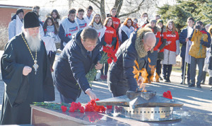 Отец Геннадий, В.И. Борзенко, А.М. Агрызков возлагают цветы к Вечному огню.