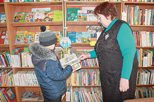 Ведущий библиотекарь Л.И. Савельева знакомит читателей с книгами.