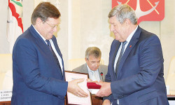 Е.П. Луганцев вручает почетный знак В.И. Борзенко (слева).