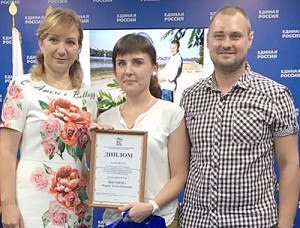 Л.Н. Тутова награждает семью Цыгановых.